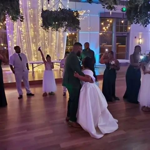 Newlyweds dancing beneath reception lights
