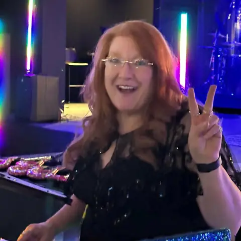 DJ Betty hosting an event with colorful lighting