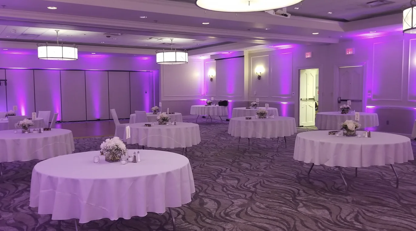 Wedding reception room illuminated with purple uplighting